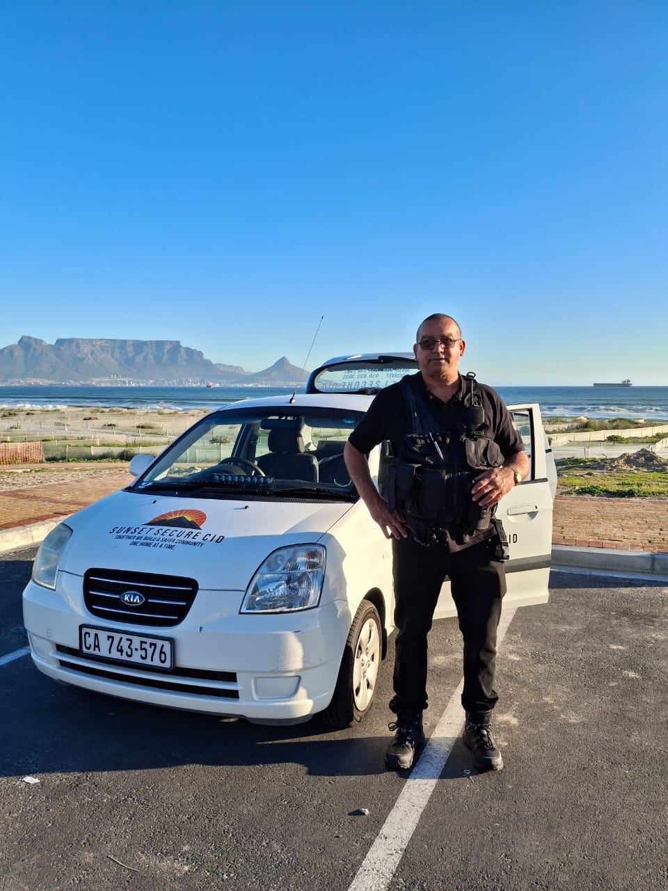 Michael Scholtz, Co-CEO of Sunset Secure CID, in uniform in front of a marked patrol vehicle